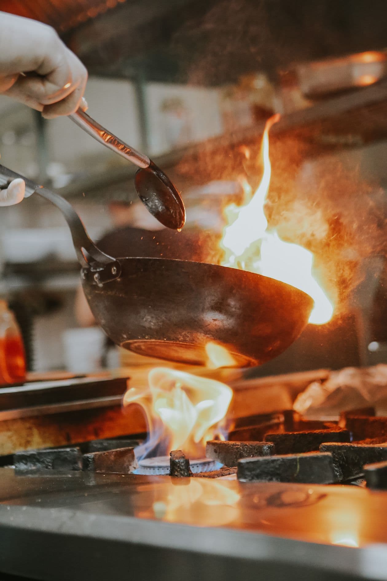 Chef tossing noodles in a flaming wok at Golden Chinese
